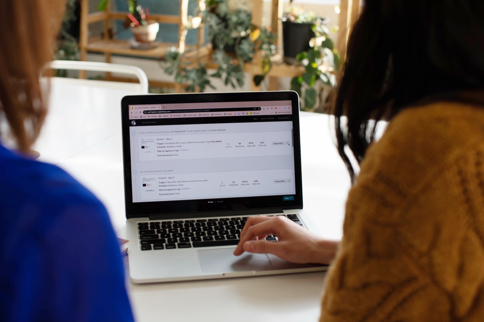 Two marketers reviewing an email campaign in Mailchimp on a laptop.